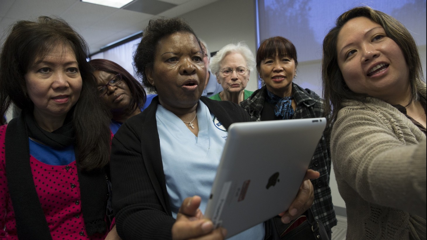 women looking in awe at an iPad