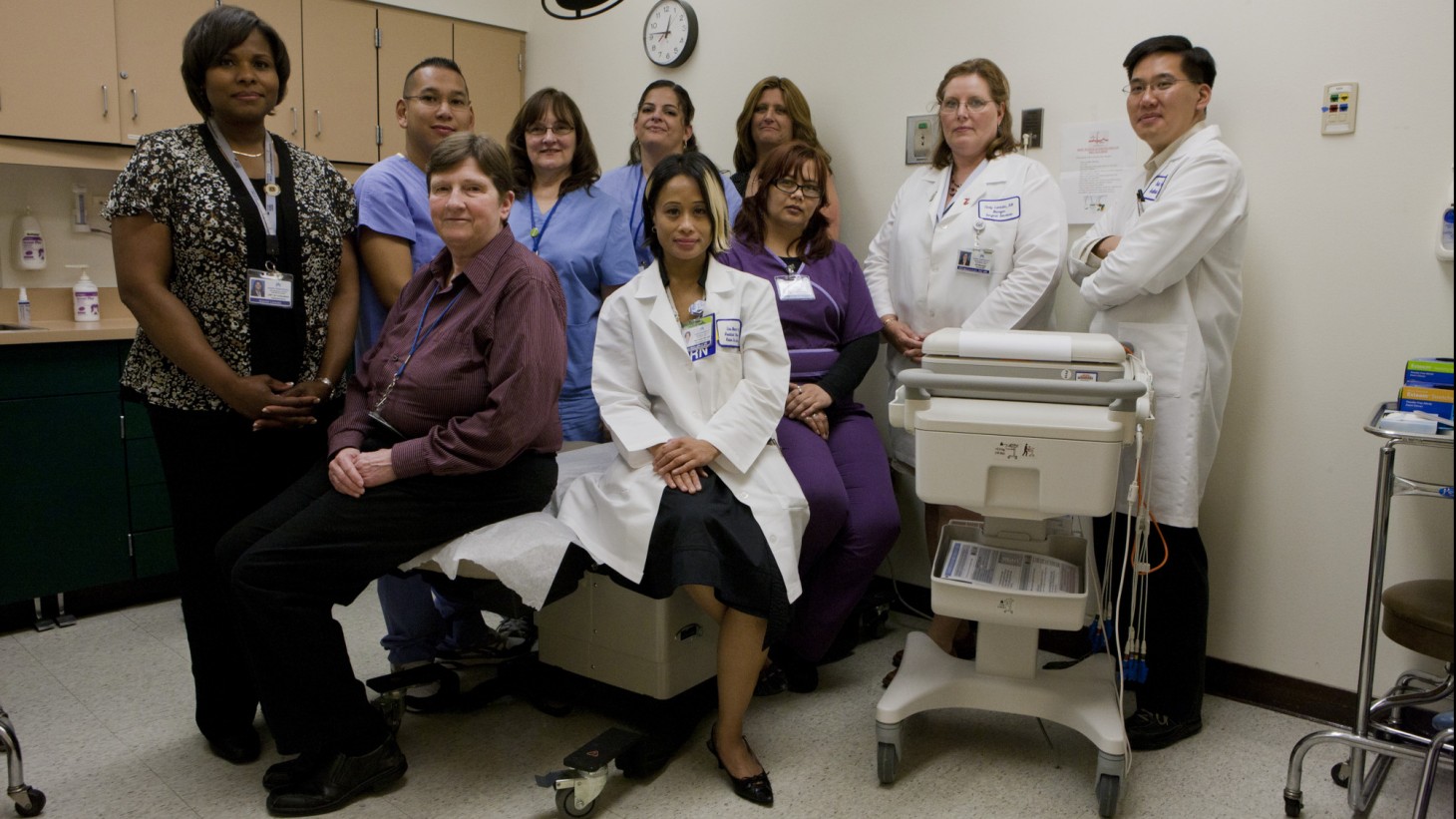 a group of health care providers posing in a hospital room 