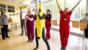 Health care workers (including one dressed a giant banana) exercising together