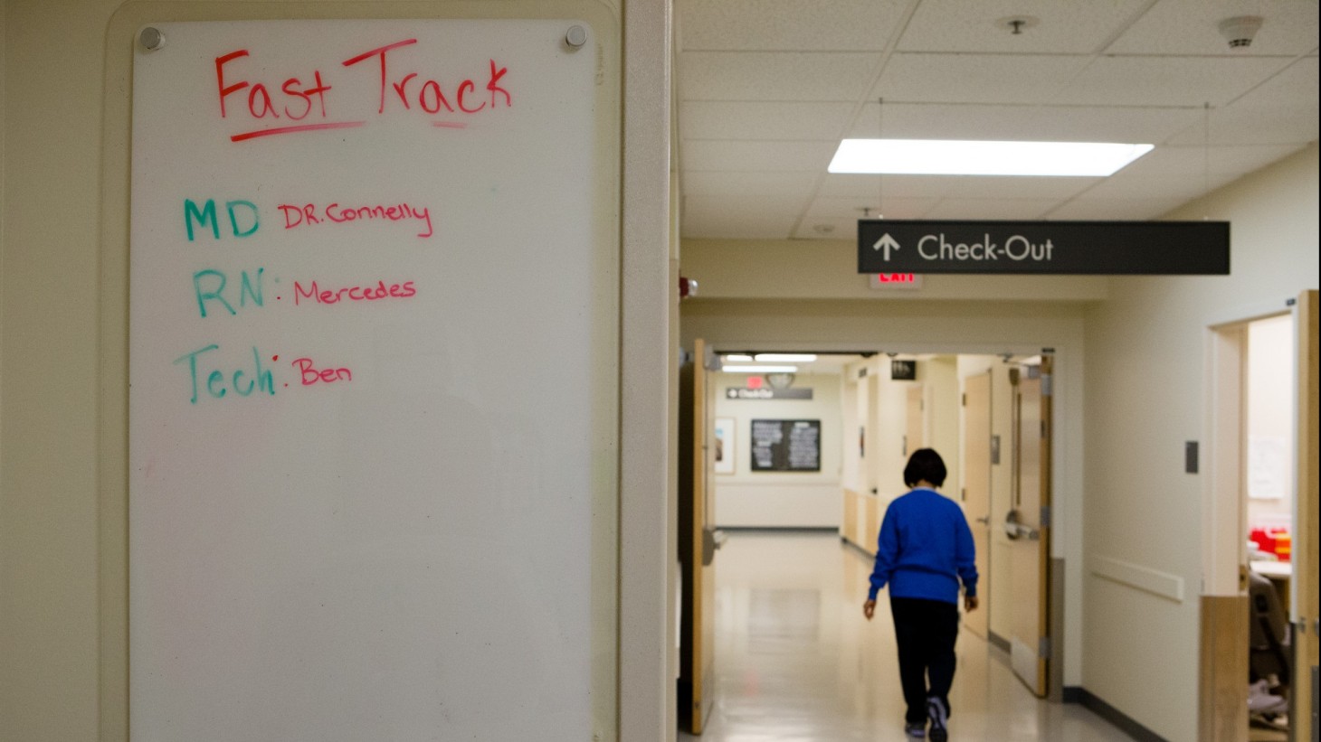 White board reading "fast track" and person walking under a sign that says "check out"